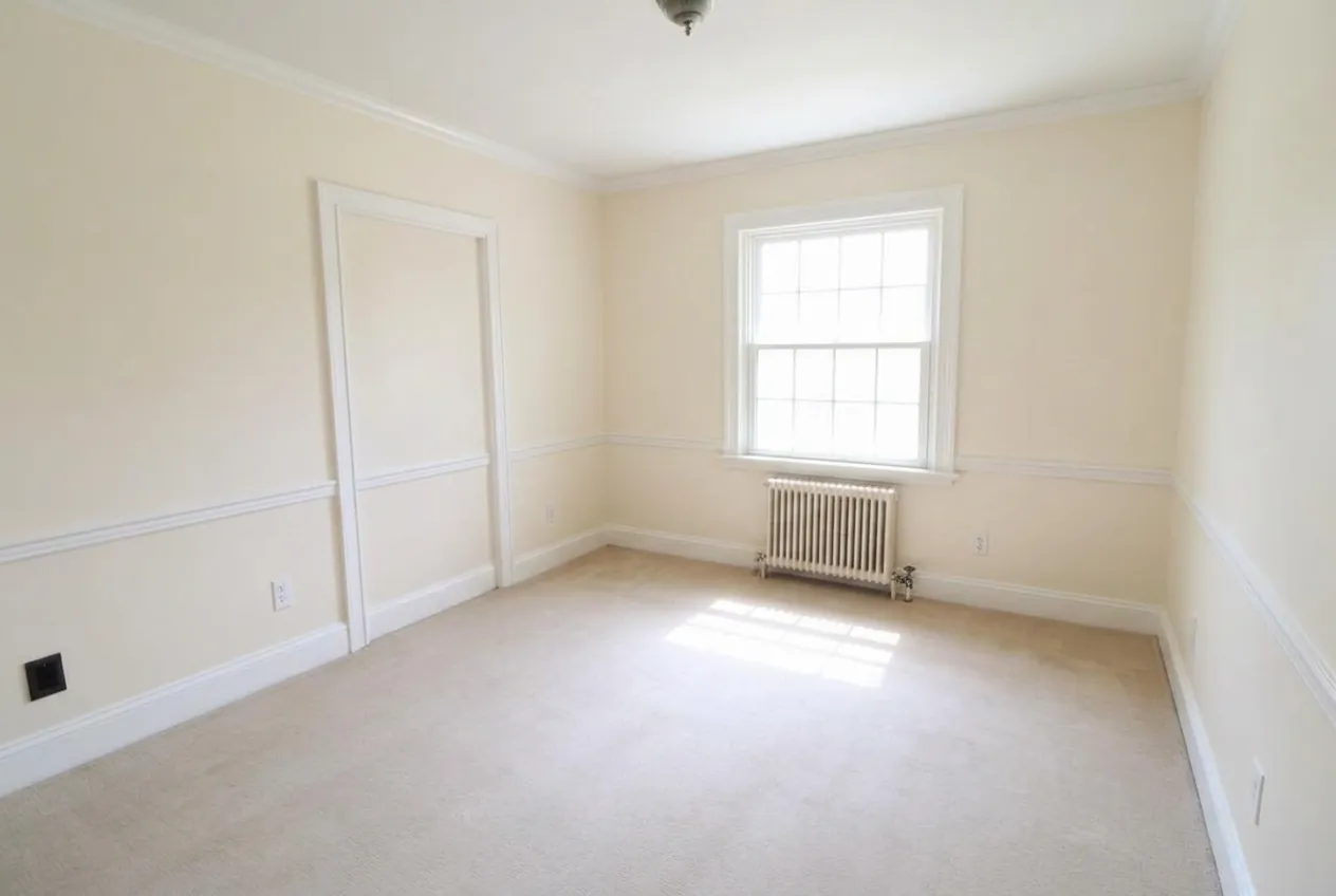 After interior painting: New Rochelle living room repainted in warm off-white with crisp white trim by Westchester house painters