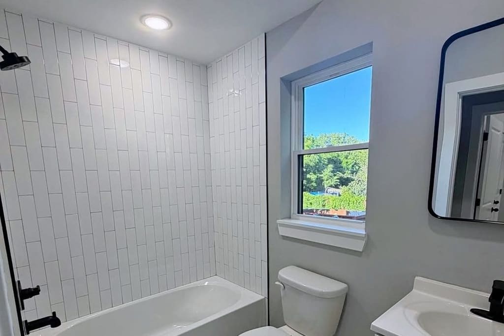 Renovated white Bronx bathroom with modern tile and vanity